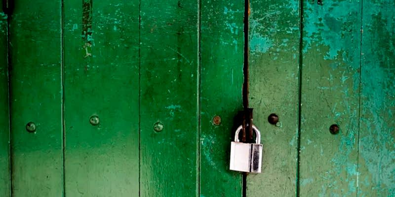 Bolt cutters positioned on a padlock shackle at a Las Vegas gate